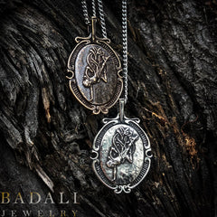 a bronze and a silver version of the Ascendant Warrior Cameo on a background of tree bark