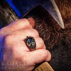 Dol Guldur Ring on a masculine hand, which is holding an axe.  